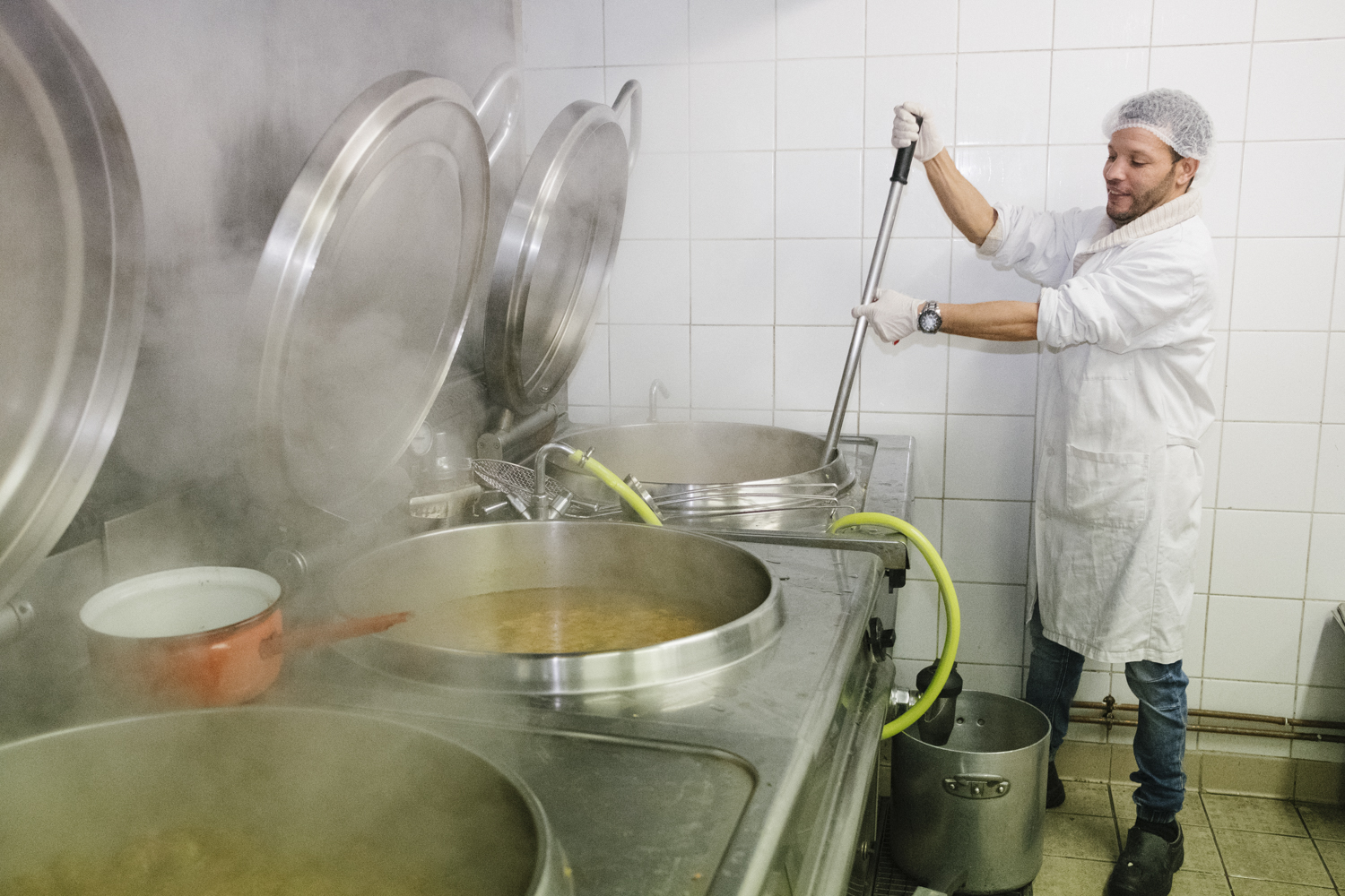 Dans la cuisine de l'association La Chorba, Brahim remue la soupe.