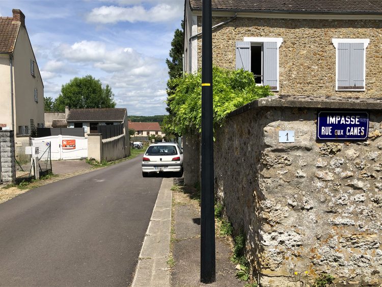 Le village de Lainville-en-Vexin où s'est tenu le restaurant éphémère le 20 et 21 mai 2022 est une commune rurale dénuée de commerces de bouche. Une rue et un mur de cette commune avec un panneau : impasse Rue aux canes