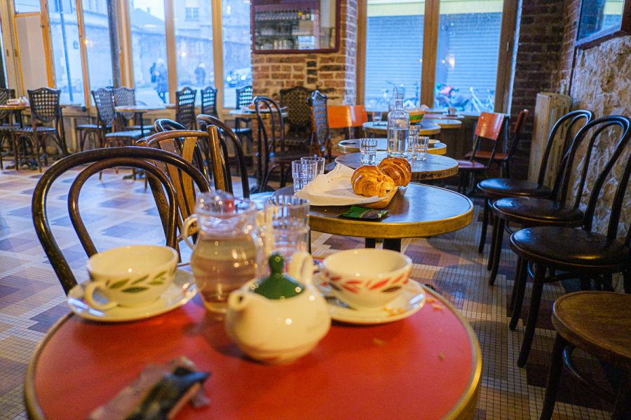 Vue en perspective sur les tables couvertes de tasses de café vides et de croisants frais.