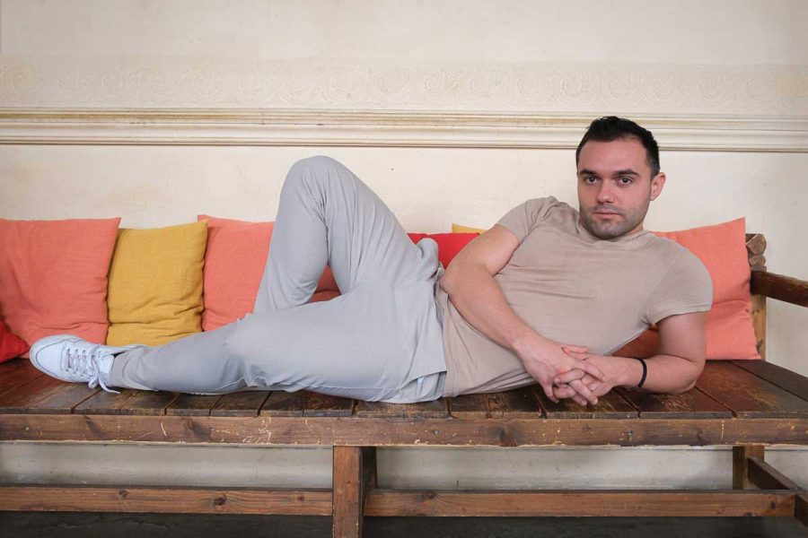 Le comédien, Alexandre Liberati, allongé sur une banquette en bois.