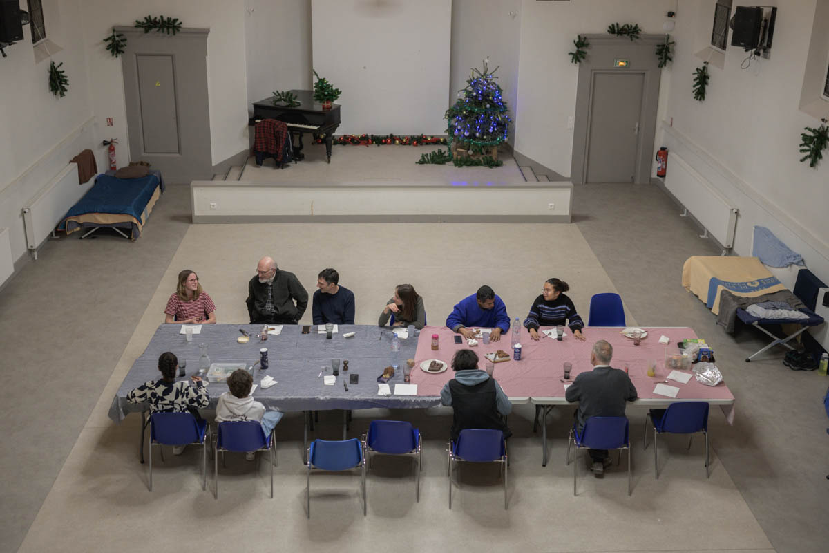 DIx personnes attablées autour d'une table à la maison paroissiale de l'église Saint-Ambroise