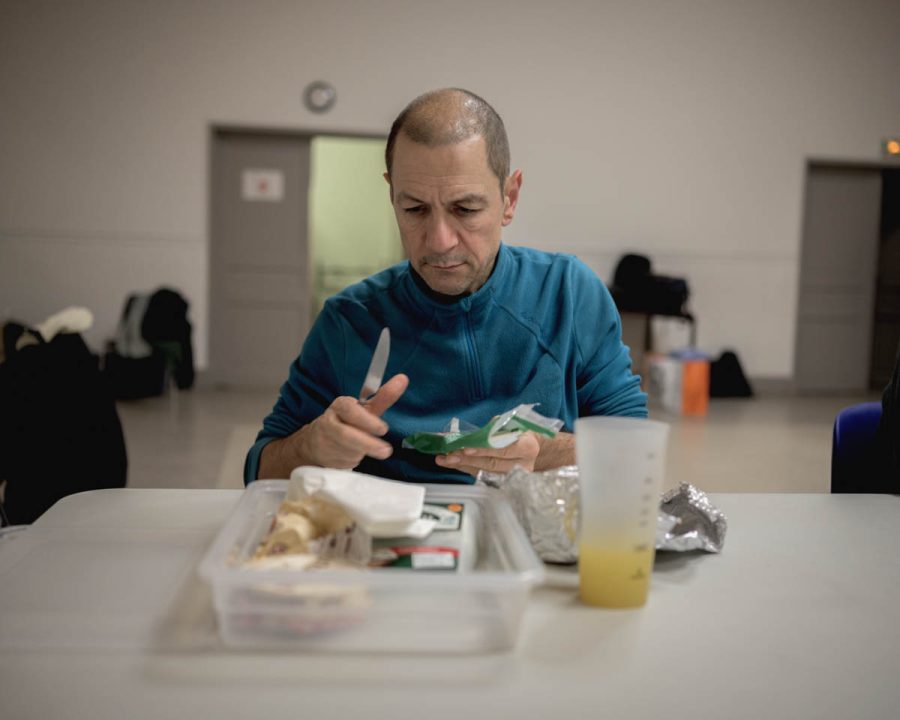 Un homme assis à une table prépare un repas.